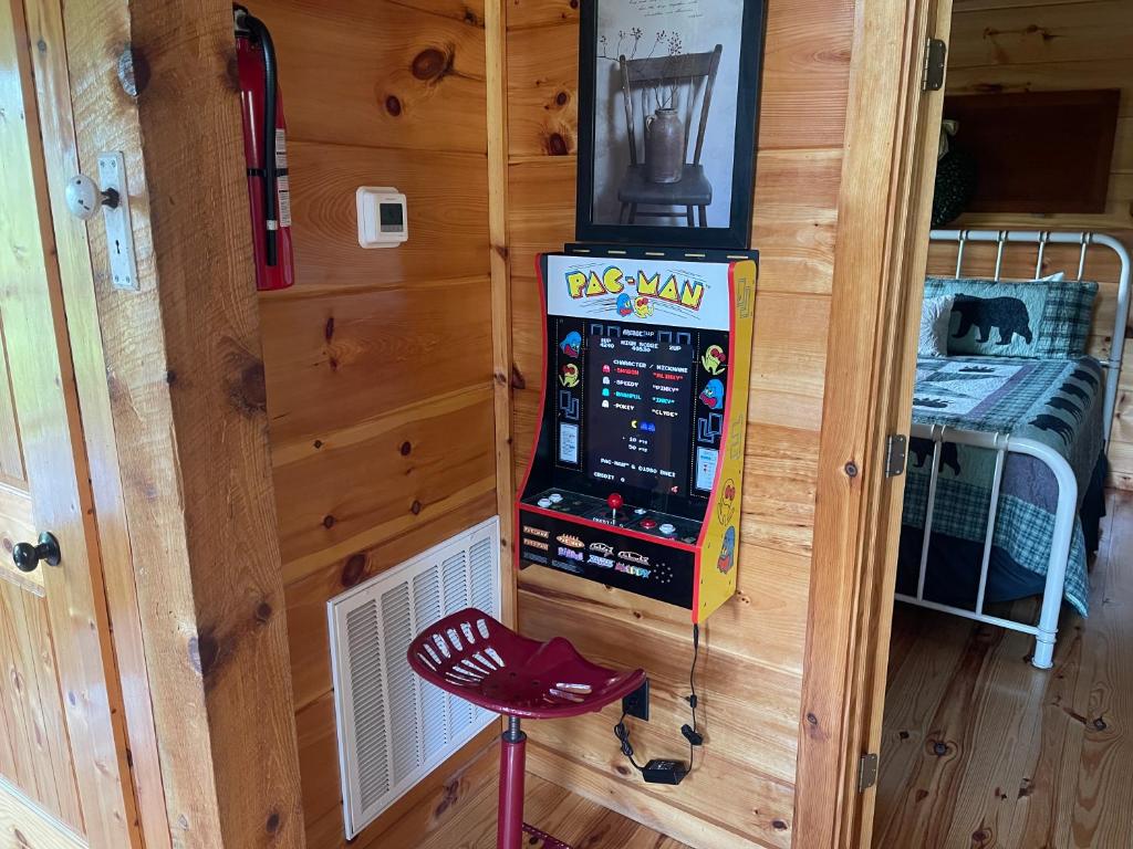 a room with a slot machine and a red stool at Bear Bottom View in Sevierville