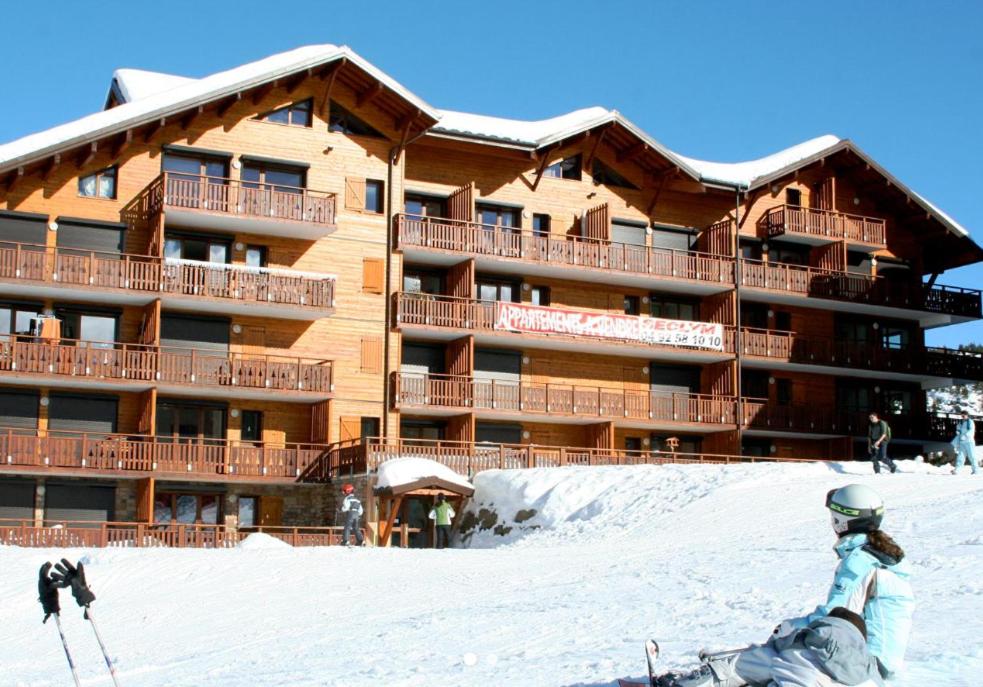 a ski lodge with people in front of it in the snow at Eden des Cimes, La Joue du Loup in La Joue du Loup