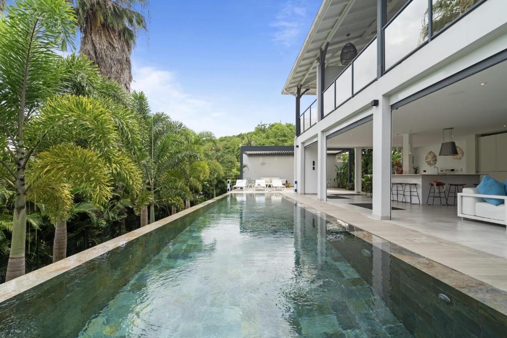 an infinity pool in the backyard of a house at Villa Ti Karibu in Les Trois-Îlets