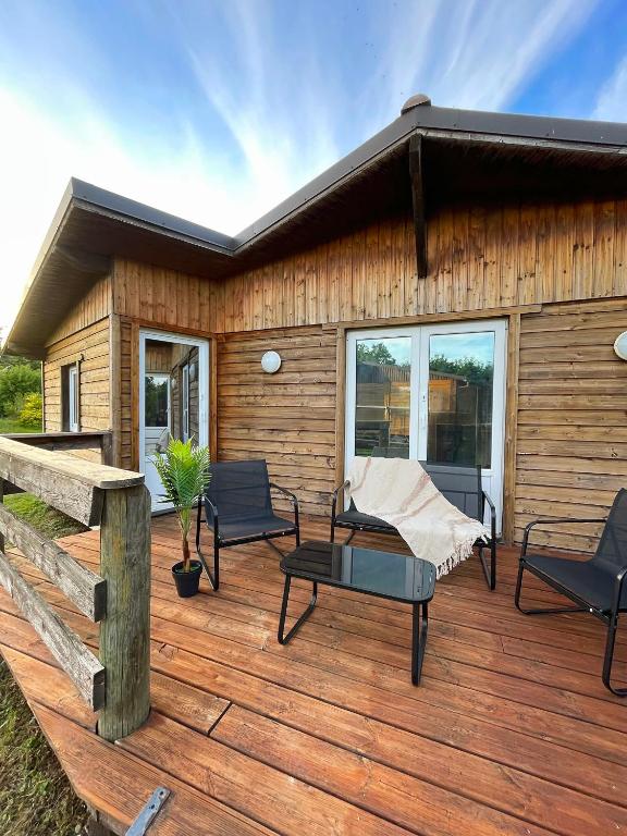 a wooden deck with chairs and a house at Chalet à Rhodes in Rhodes