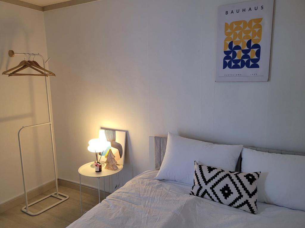 a bedroom with a bed and a table with a lamp at Mi casa in Seoul