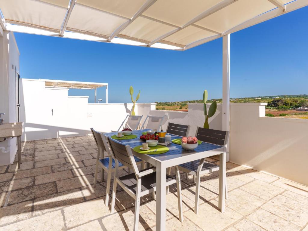 a dining room with a table and chairs on a patio at Mansarda - SUNSET in Torre Pali
