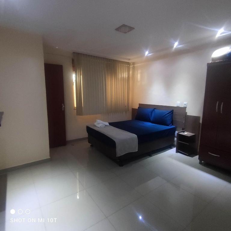 a bedroom with a blue bed in a room at Apartamento inteiro in Itaperuna