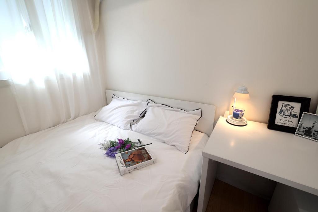 a white bed with a tray of flowers on it at Stay107 in Seoul