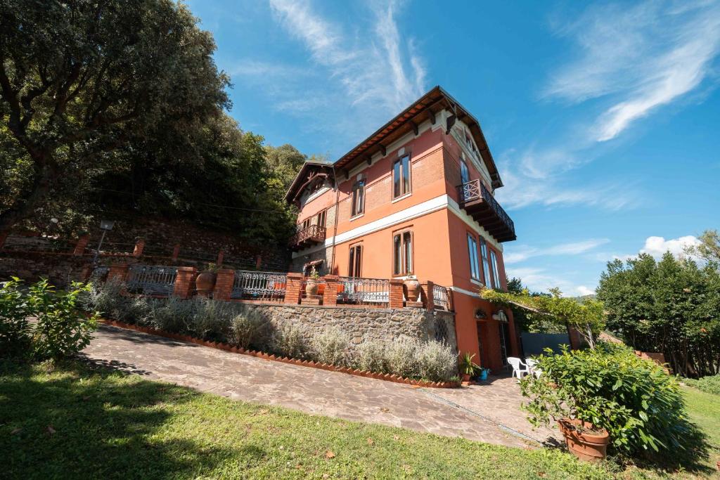 een groot oranje huis met een hek eromheen bij Villa Claudia in Montecatini Terme