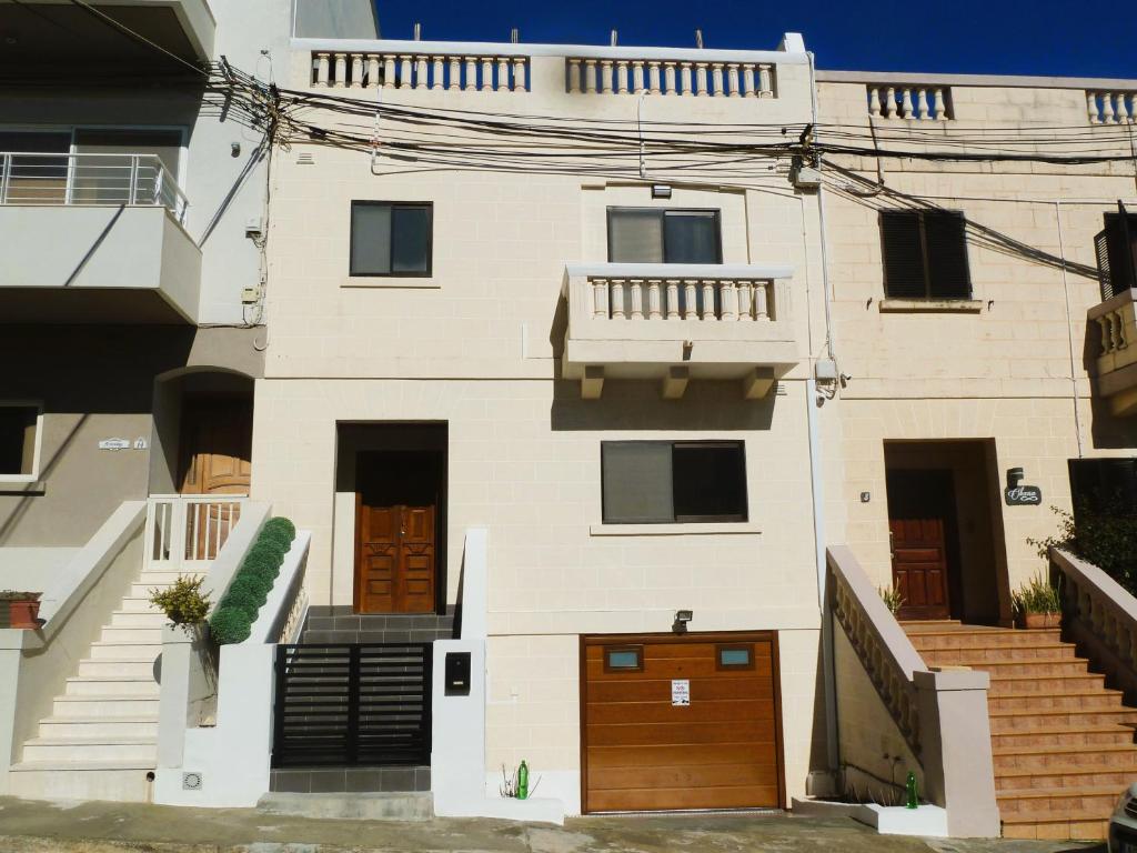 a white house with brown doors and stairs at Bright & Spacious Private Room, Bathroom & Terrace in Swieqi, Prime Location! in Is-Swieqi