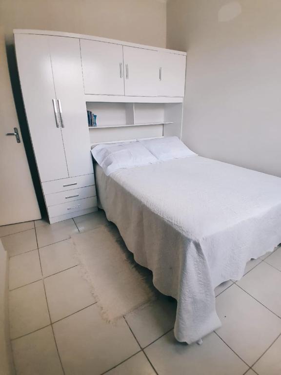 a bed in a room with a white cabinet at Apartamento cop 30 in Marituba