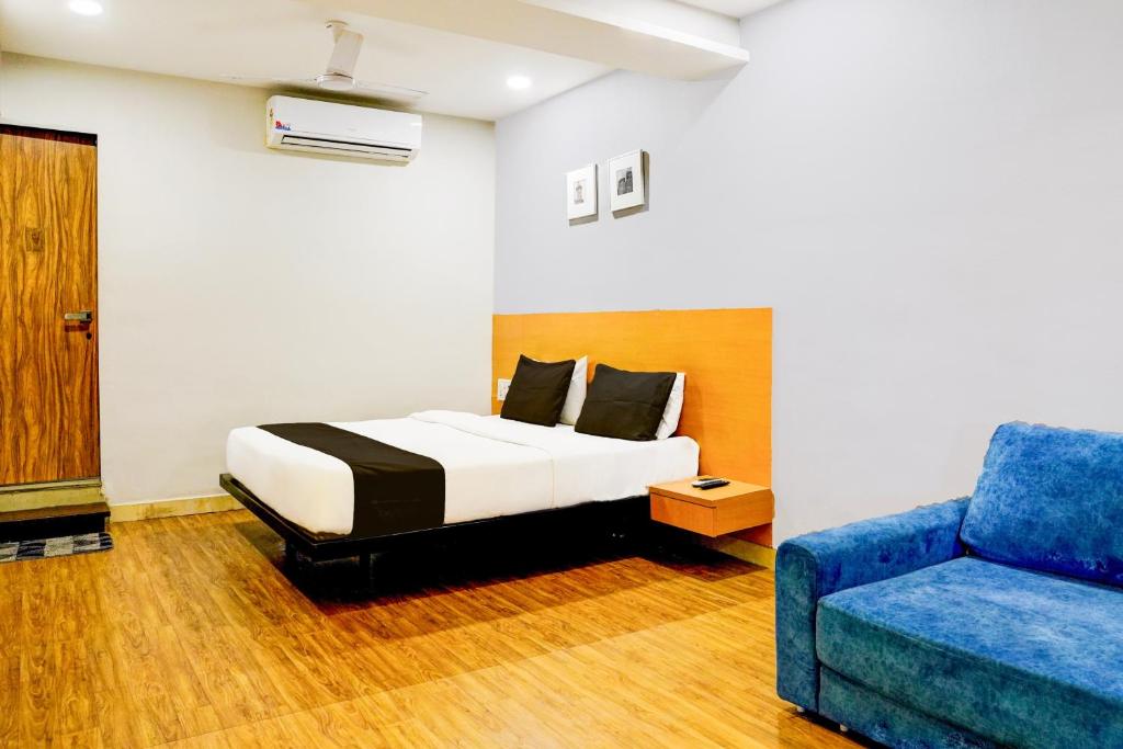 Un dormitorio con una cama y un sofá azul. en Hotel O The Park View Rooms, en Surat