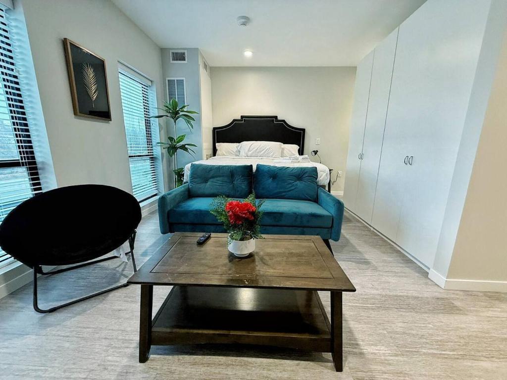 a living room with a blue couch and a coffee table at Verdant Luxe Studio in Des Moines