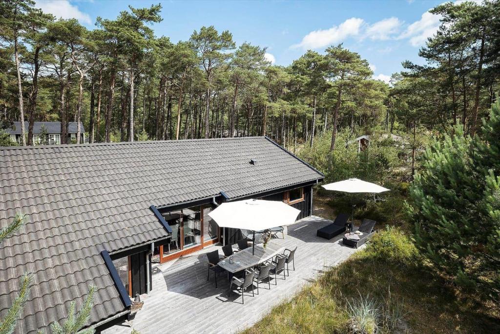ein Haus mit einer Terrasse mit Tischen und Sonnenschirmen in der Unterkunft 2706 Nexø - Harevej 11 in Neksø