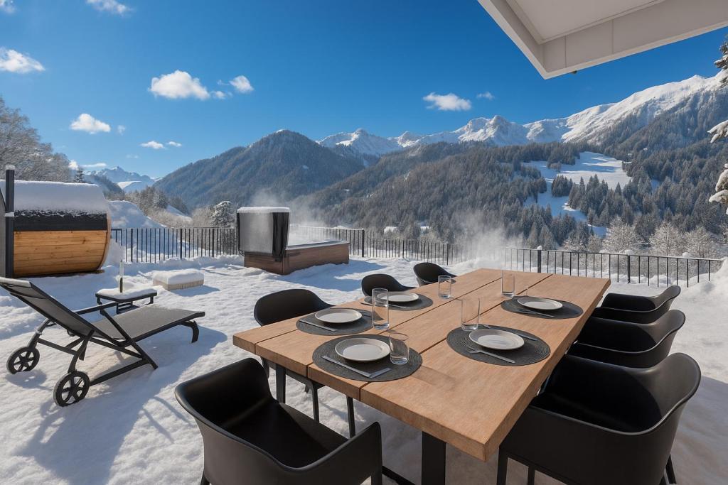 - une salle à manger avec une table, des chaises et des montagnes dans l'établissement Chalet Élégance alpine - BO Immobilier - La Chapelle D'Abondance, à La Chapelle-dʼAbondance