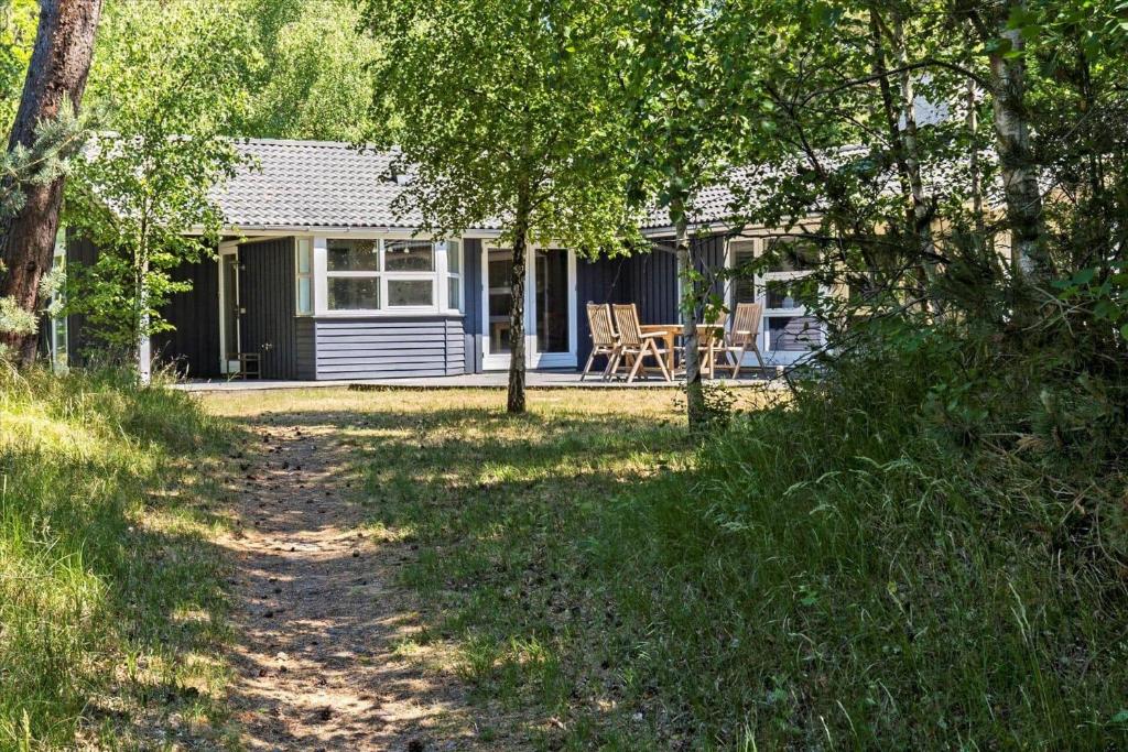 a blue cottage with a table and chairs in a yard at 1465 Aakirkeby - Poseregårdsvejen 5 in Vester Sømarken