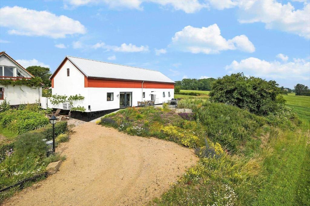 un granero en un camino de tierra al lado de un campo en 5638 Svaneke - Oksemyrevejen 2 B, en Svaneke