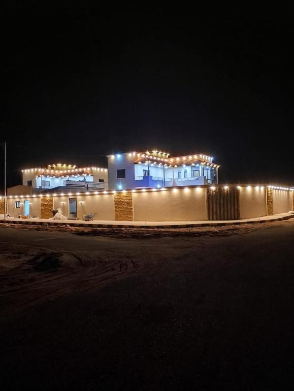 瓦迪拉姆Wadi Rum chalets的夜晚亮着灯的建筑物