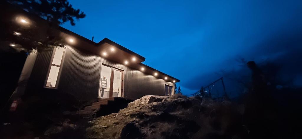 a house with lights on the side of it at night at Cabañas del Sur in Cochrane