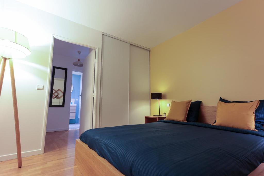 1 dormitorio con 1 cama azul y 1 lámpara en Magnifique Appartement Quartier Opera Bastille !, en París
