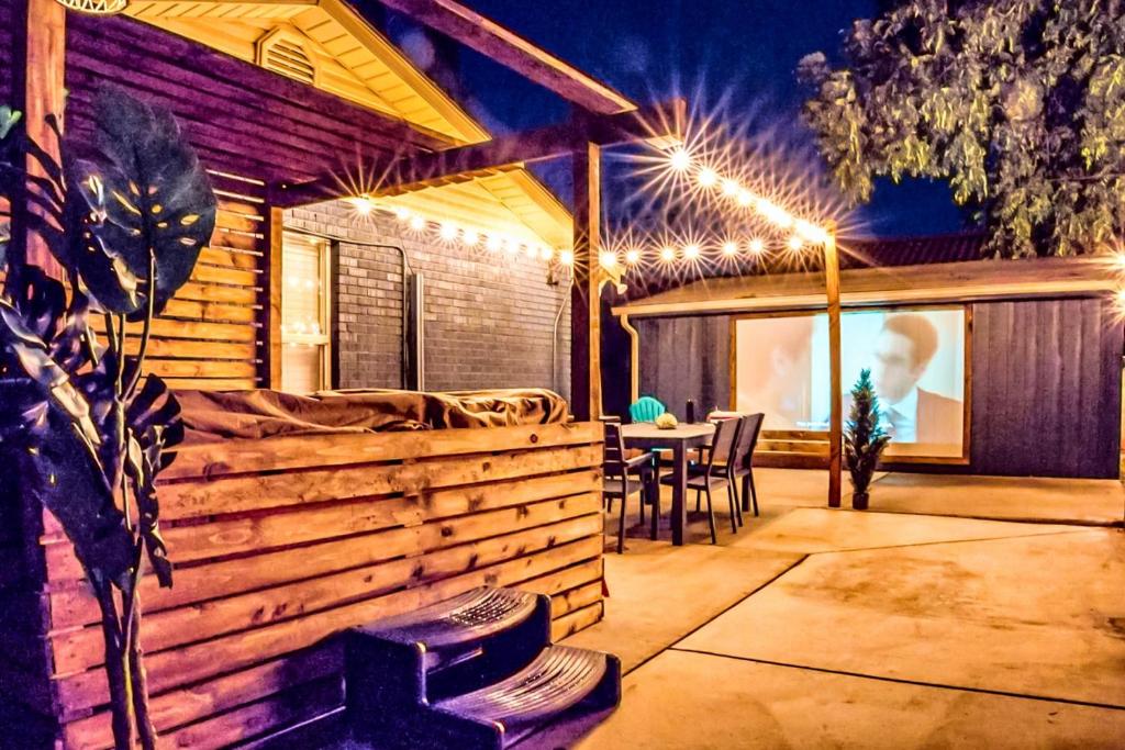 un patio con tavolo, sedie e luci di Golf Gym HotTub Pets Game room Patio a St. George