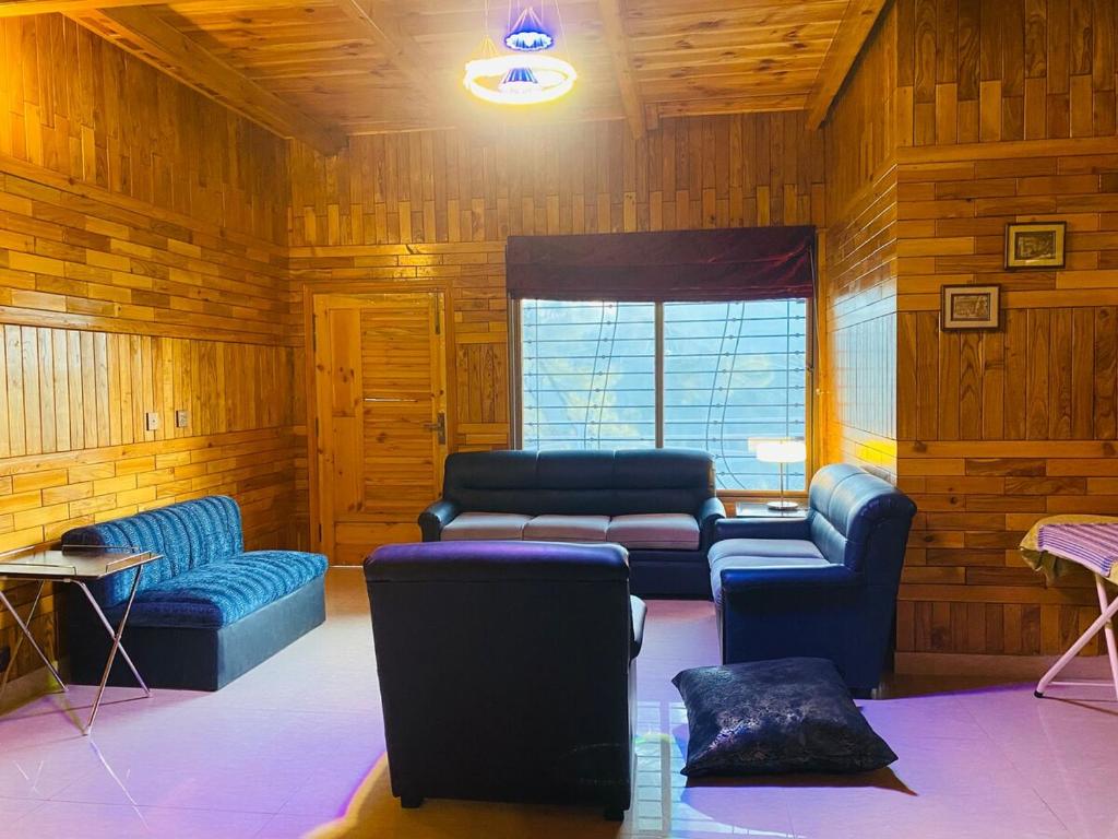 een woonkamer met twee blauwe banken en een bank bij 4BHK Dunga Gali in Dunga Gali