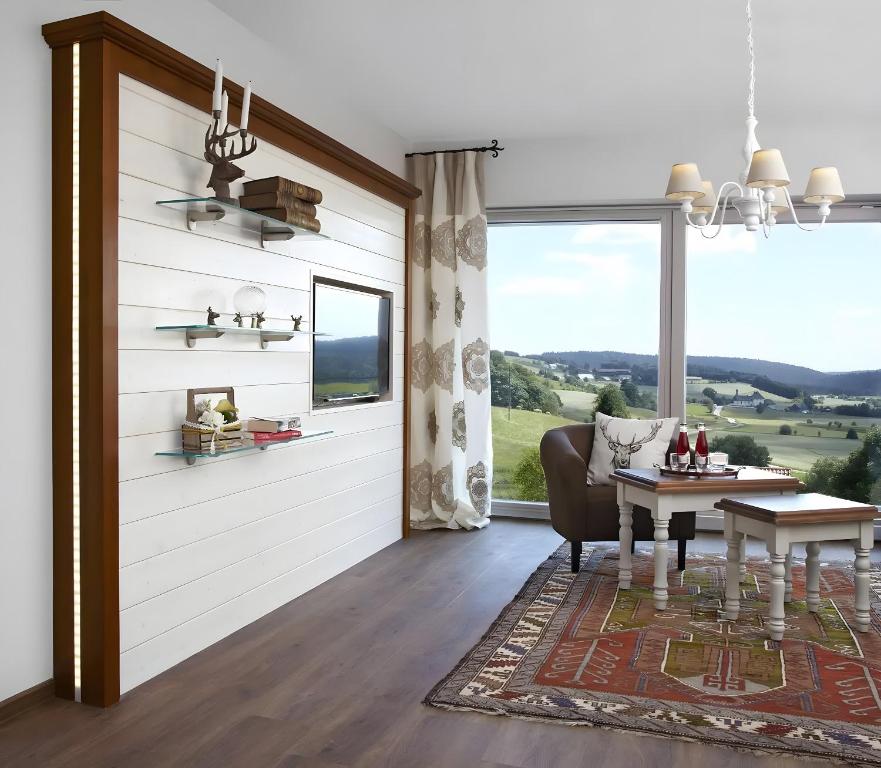 Una sala de estar con una mesa y una gran ventana. en Kuckucks, en Oberibach