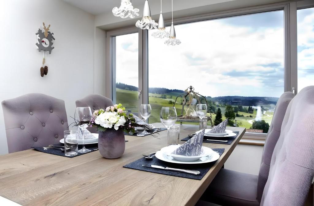 Una mesa de comedor con sillas y una gran ventana. en Chillout, en Oberibach