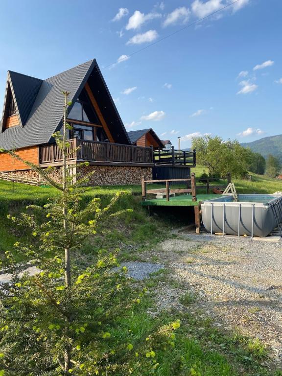 a house with a boat in front of it at Котедж A-frame Strimba in Verkhnyaya Rozhanka