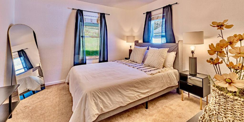 a bedroom with a large bed with blue curtains at 17 Min to NRG | Grill | Huge Yard | Private | Cozy in Oak Hill