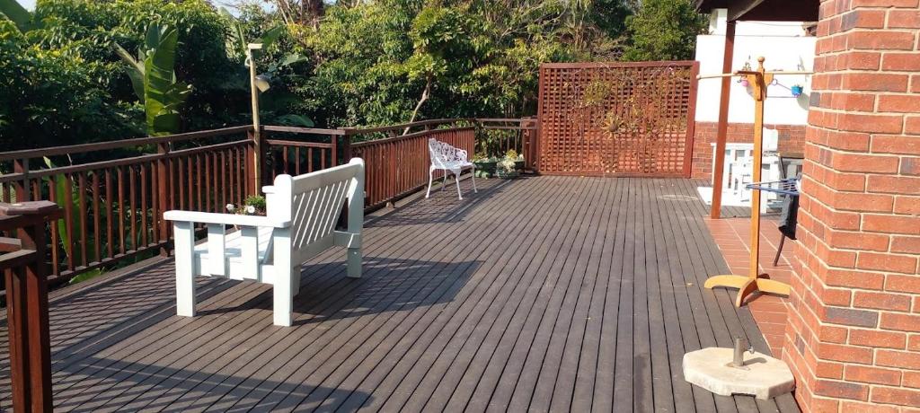 Una terraza con dos bancos y una valla de ladrillo. en T15SelborneGolfEsatePennington, en Vosburg