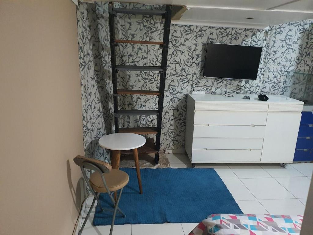 una stanza con una scrivania, una TV e uno sgabello di Apartment a Rio de Janeiro