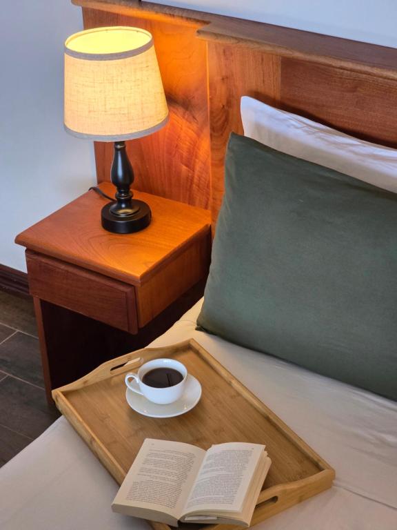 bandeja con una taza de café y un libro en la cama en Bosque Tapantí, cerca del PN Tapantí en Orosí, Cartago, Costa Rica, en Purisil