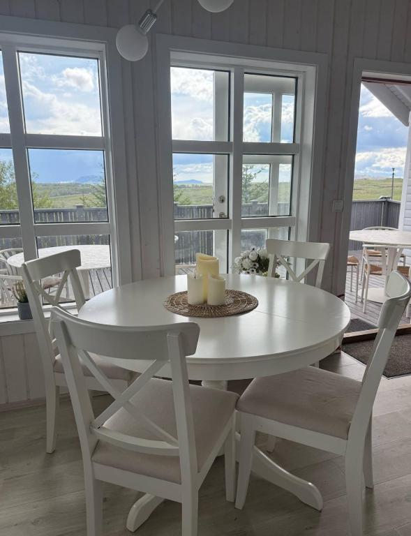 a white table and chairs in a room with windows at Cozy cottage in Golden Circle in Reykholt
