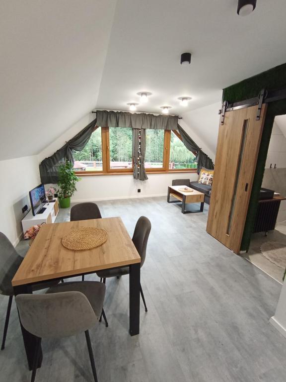 a living room with a wooden table and chairs at Domek Wrzos in Brenna