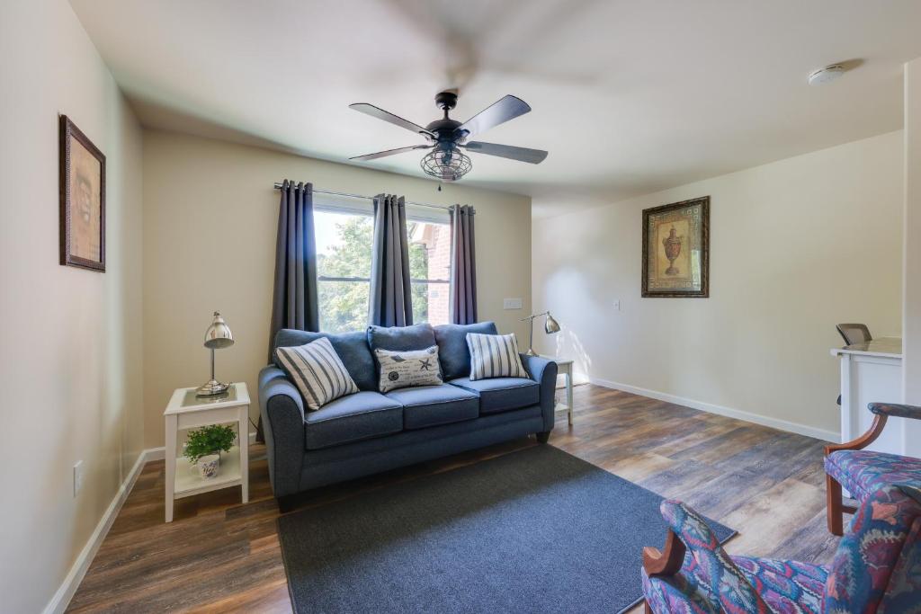 a living room with a blue couch and a ceiling fan at 6 Mi to the Summit Stylish Apt with Patio Access in Wisteria Commons