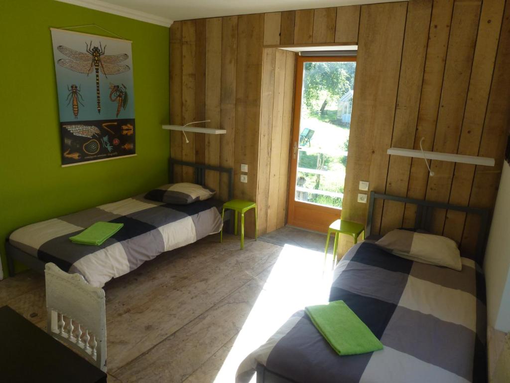 2 camas en una habitación con paredes verdes y ventana en Les Deux Vélos Chambres d'Hotes-Table d'Hotes, en Biert