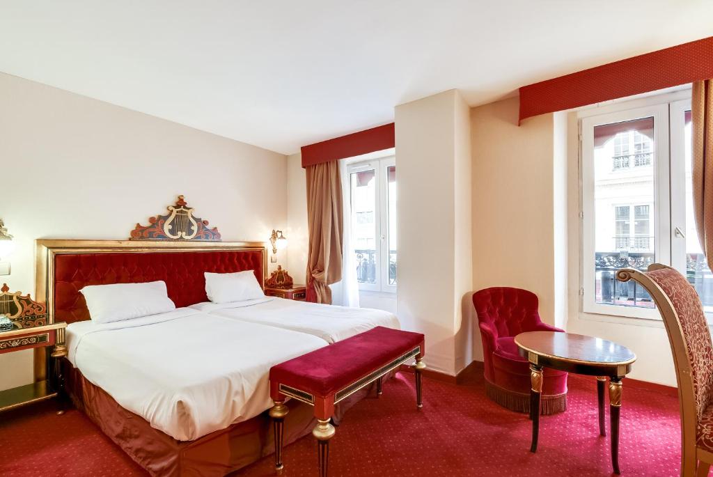 a hotel room with a bed, table, chairs and a lamp at Villa Opera Drouot in Paris