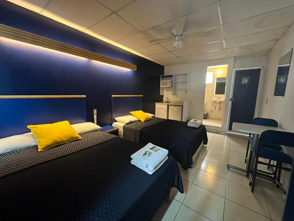 a hotel room with two beds with yellow pillows at Hotel Vagabundo Expo Guadalajara in Guadalajara