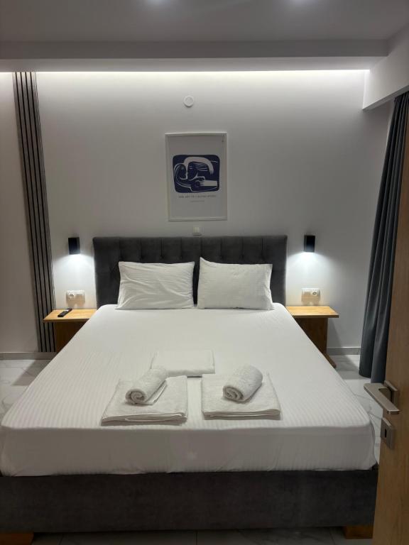 een slaapkamer met een bed met twee slippers erop bij Project Georgiadi #1 - Modern Apartment in peaceful neighborhood - 15 mins from Loutra Pozar in Aridaía