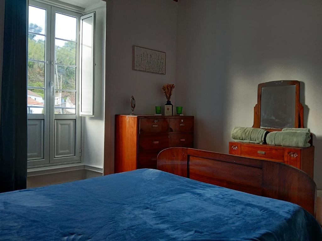 une chambre avec un lit, une commode et un miroir dans l'établissement Botânico Guesthouse, à Nordeste