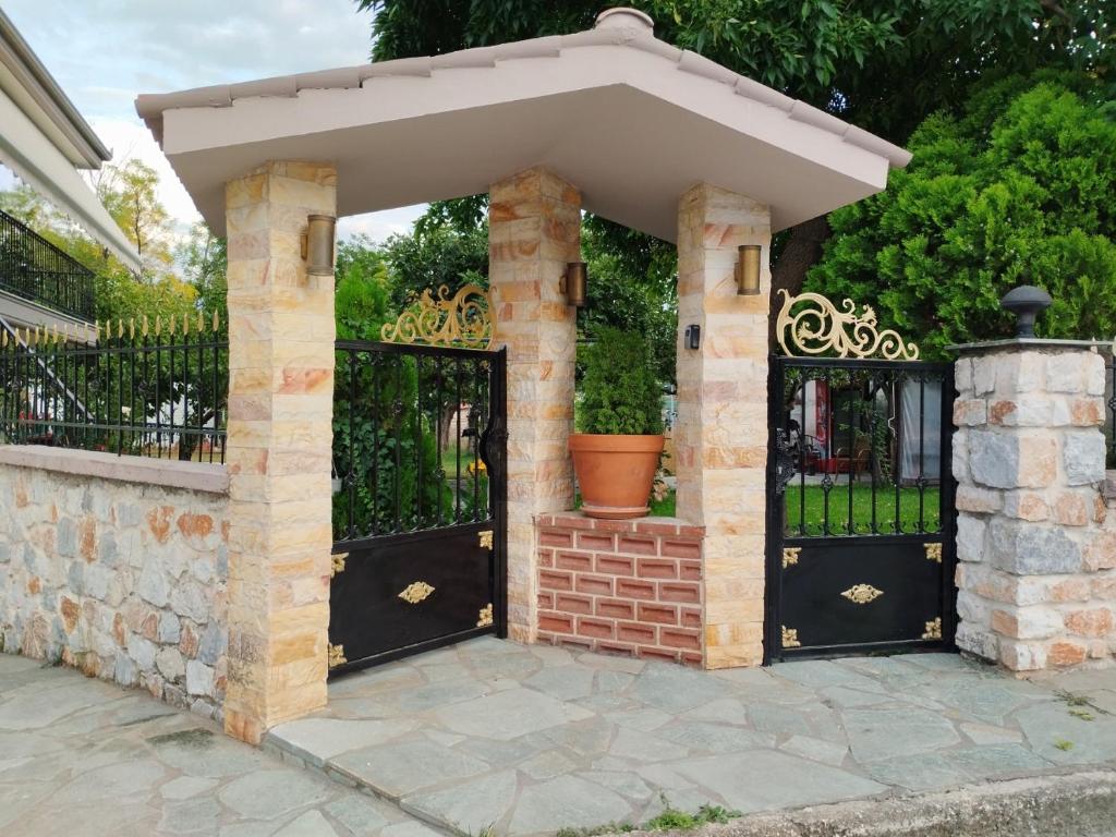 an entrance to a house with black doors and a brick wall at Smaro house in Filótas