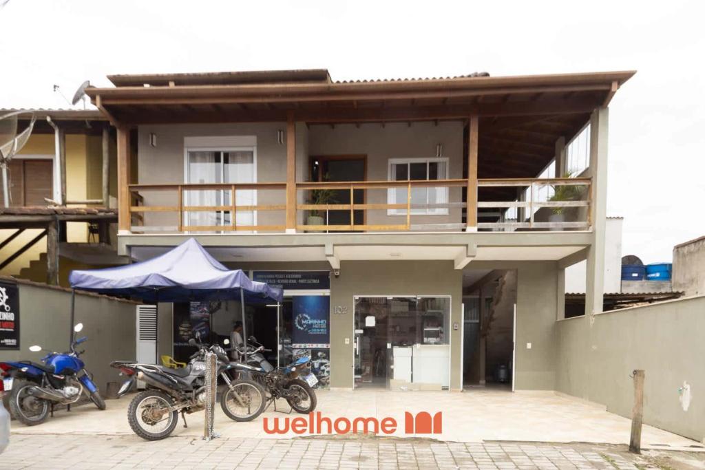 zwei Motorräder, die vor einem Gebäude geparkt sind in der Unterkunft Casa em Maresias com Churrasqueira e area de lazer in Maresias