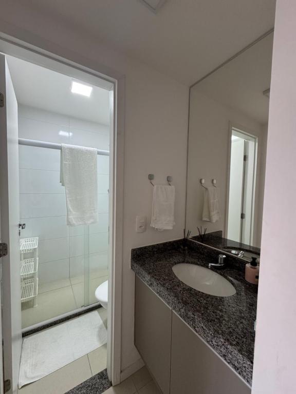 a bathroom with a sink and a glass shower at Condomínio Paraiso dos Coqueiros in Camaçari