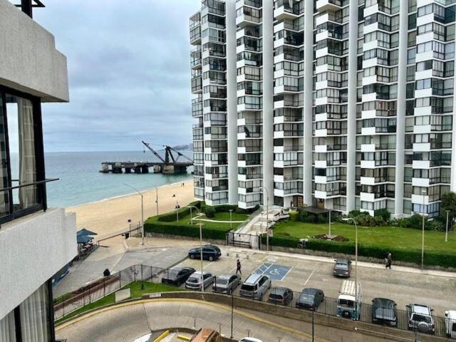 a large building with a parking lot in front of the ocean at Acogedor depto con vista al mar in Viña del Mar