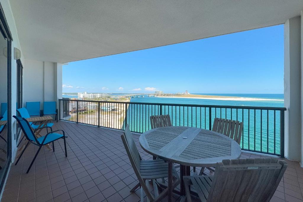 a balcony with a table and chairs and the ocean at Grand Pointe Unit 706 in Orange Beach