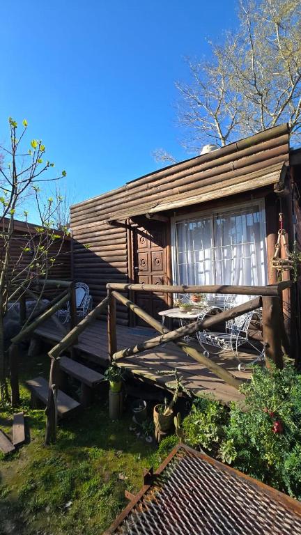 a wooden cabin with a window on a deck at Cabañas el descanso in Chascomús