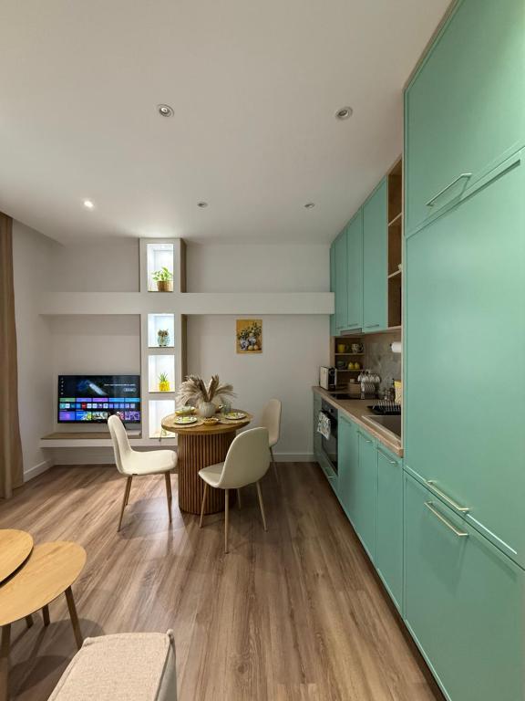 a kitchen with blue cabinets and a table and chairs at Lemon Garden Cozy 2BR Apt Private Garden Center in Tirana