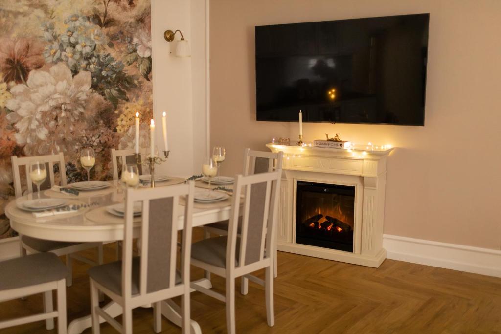 a dining room with a table and a fireplace at Tynska apartment in Prague