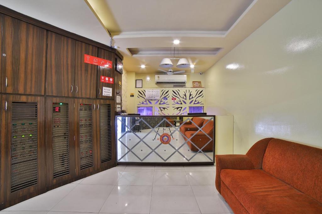een lobby met een wachtkamer met een bank erin bij Hotel O Kalash Residency in Ahmedabad