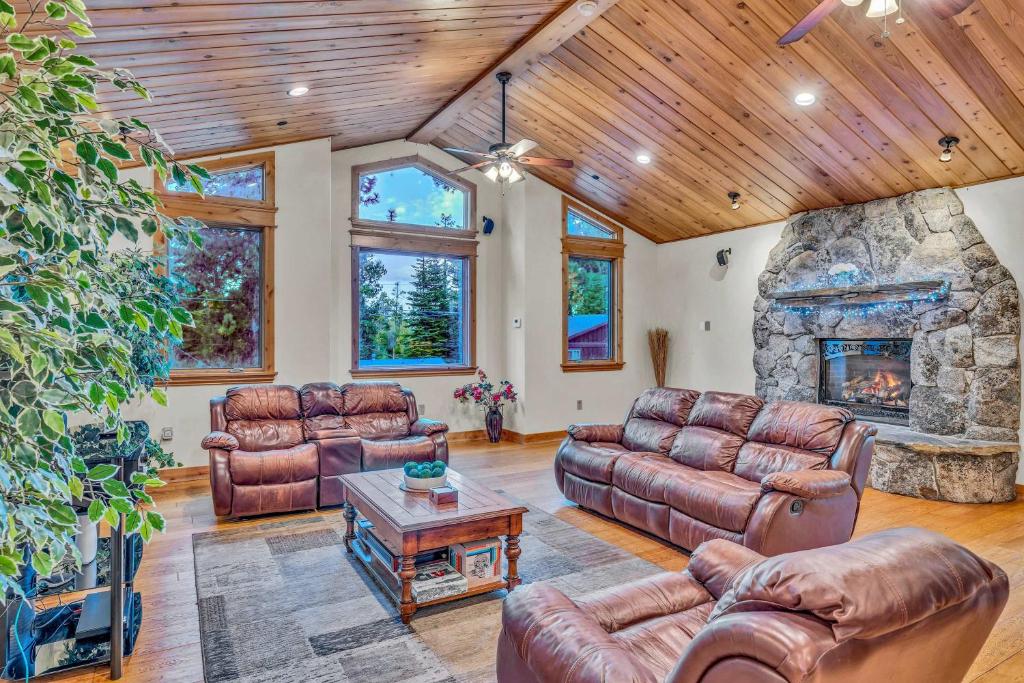 un soggiorno con mobili in pelle e camino in pietra di Tahoe Island Retreat Hot Tub & Game Room a Tallac Village