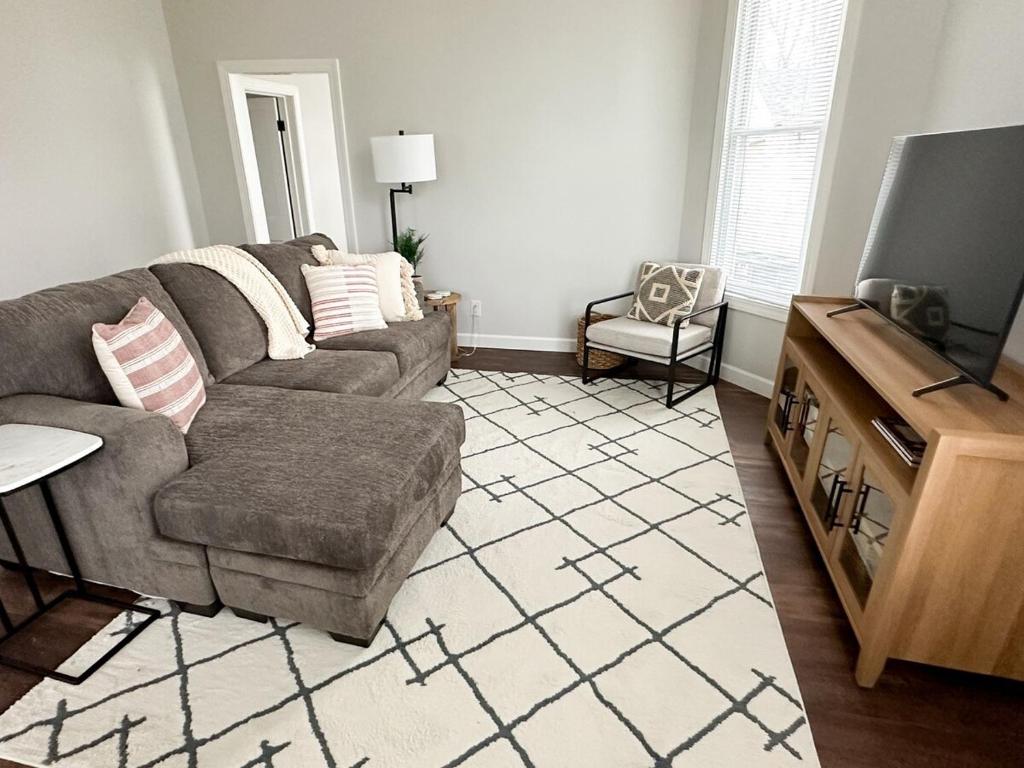 a living room with a couch and a tv at Modern 4 BDRM Renovated Spacious near U of E and Downtown in Evansville