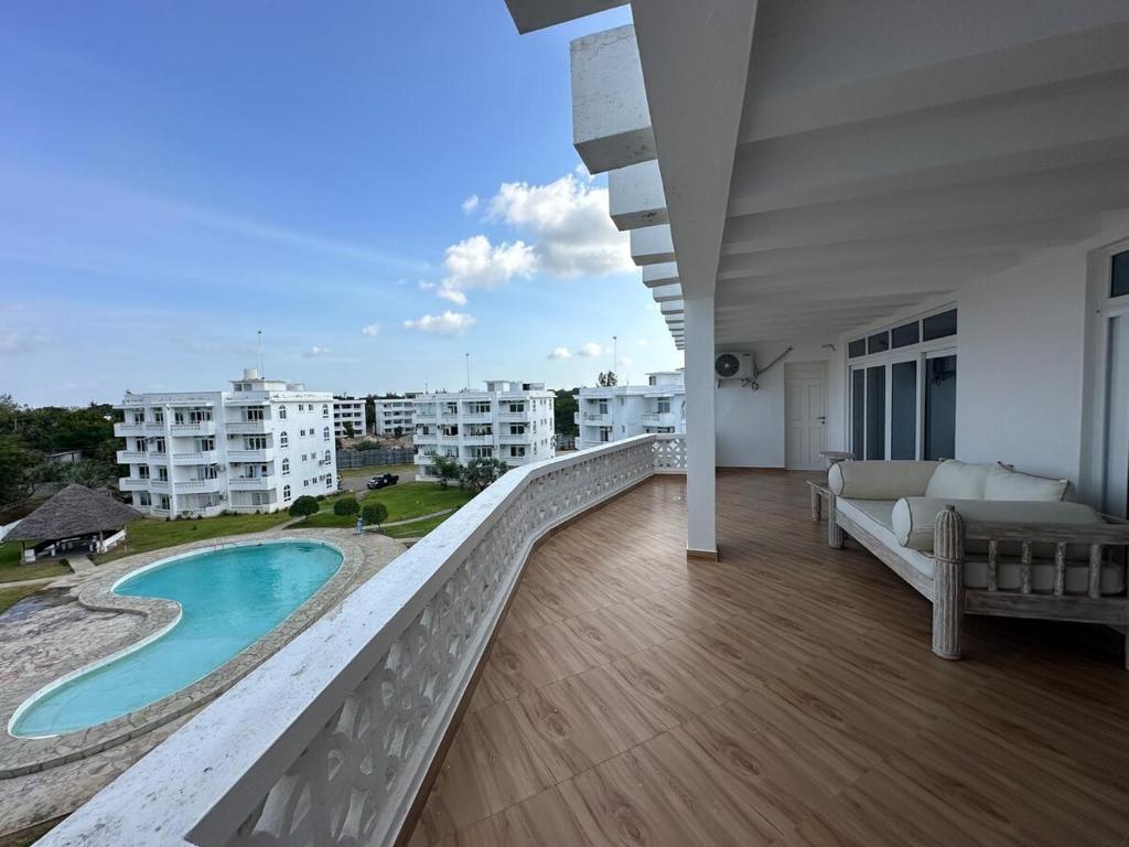 een balkon met uitzicht op een zwembad en gebouwen bij Nyumba Alfajiry in Malindi