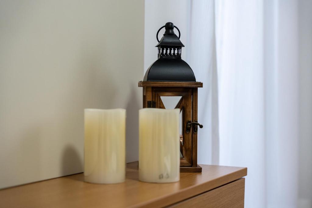two candles on a wooden table with a lantern at Mount Inn 123 in Zlatibor